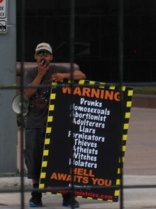 A man with a megaphone protesting the Houston Sidewalk Art Show, October 2011. As a Christian enjoying the show, I felt ashamed of my more legalistic brethren on the other side of the fence. How does this promote the Gospel? Photo by the author.